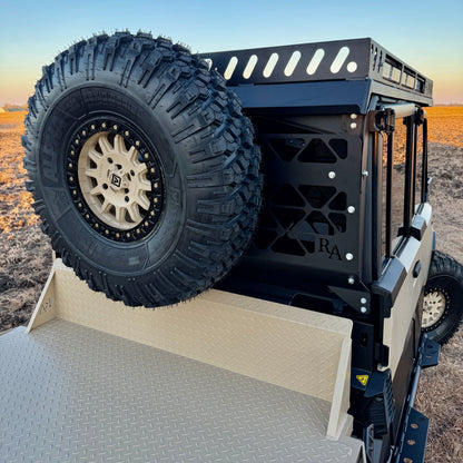 2026 Can-Am Defender HD11 Whiskey Alpha build showing rear armor, bed rack system, and utility add-on equipment.