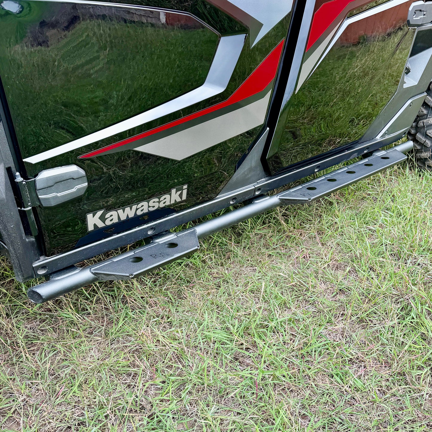 Black powder-coated side steps mounted on Kawasaki Ridge utility vehicle